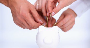 Putting coin into the piggy bank
